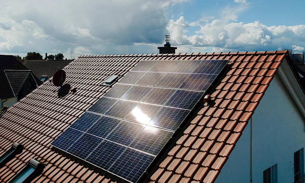Fertig montierte Photovoltaikanlage mit schwarzen Solarmodulen auf einem Ziegeldach.